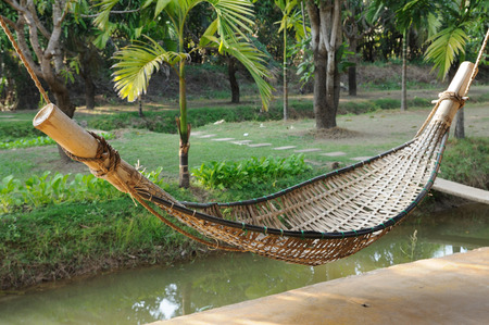 Old bamboo hammock hanging in gardenの写真素材