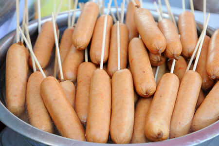 Meat sausages on sticks in bowl.の写真素材