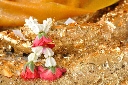Beautiful garland-flower with rose hanging on Buddha statue.の写真素材
