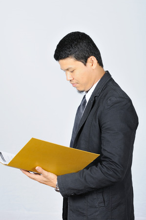 Business-man holding and checking work with yellow folder.の写真素材