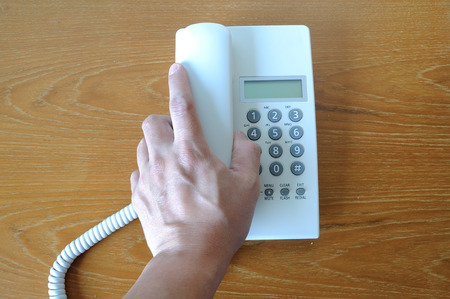 Single telephone on wooden table, business concept.