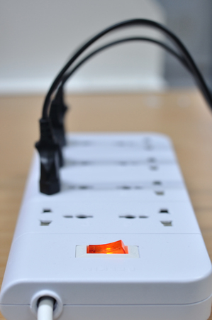 White power-strip using on wooden table.の写真素材