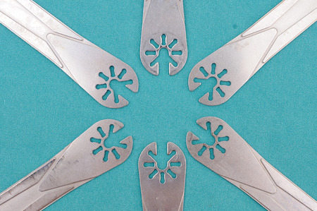 Surgery oscillating saw blades on green cloth.
