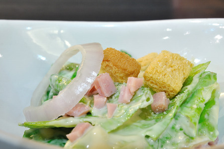 Caesar salad with crispy bread in white bowl.の写真素材