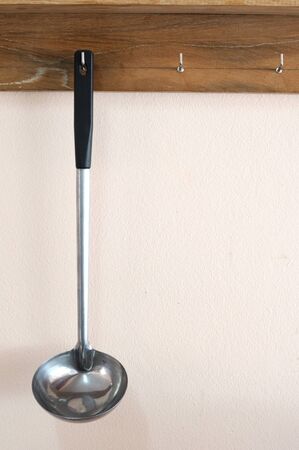 Single scoop with long handle hanging on wooden shelf.の写真素材