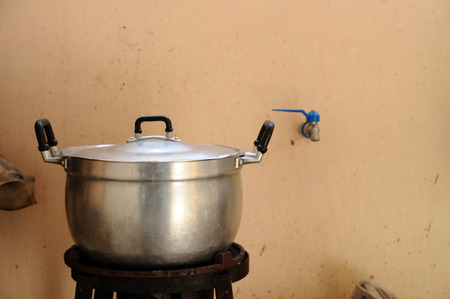 Old aluminium pot on gas stove, still life.
