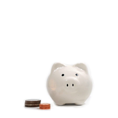 White ceramic piggy bank with coinsの写真素材