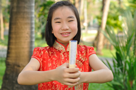 Asia female teenager wear red suit pose for take photo in garden, Chinese New Year traditionsの写真素材