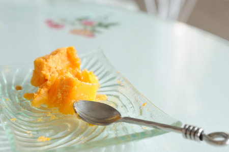 Piece of crumbs orange cake with stainless spoonの写真素材