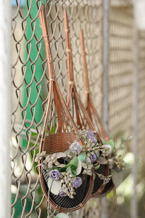 Dirty flower baskets with artificial flowers on wire wallの写真素材