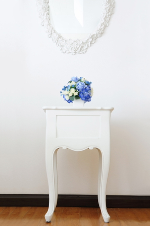 Vintage lamp and artificial bouquet on white small desk, Home decoration conceptの写真素材