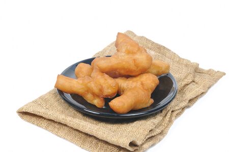 Chinese deep fried dough stick in black plate and sack on white background.の写真素材