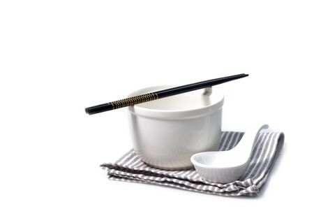 Ceramic bowl and spoon with chopsticks on gray strip napkinの写真素材