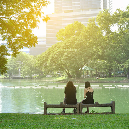 Couple love sitting together on rock bench next to big lakeの写真素材