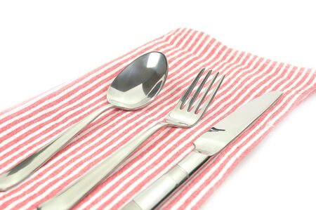 Stainless tableware set, spoon fork knife lay no red napkin utensil equipment in restaurant.の写真素材