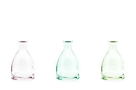 Three color transparent bottles grass on white background.の写真素材