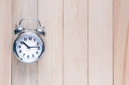 Silver alarm clock 10:15 on wooden plank with copy space.の写真素材