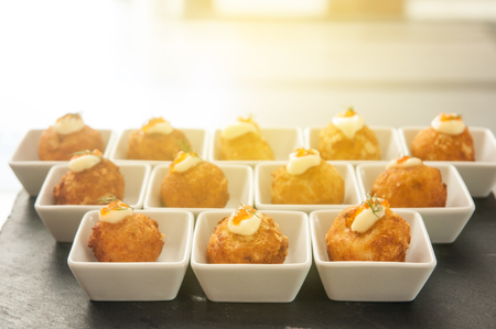 Cheese balls with cream salad in white small bowl with light flare.の写真素材