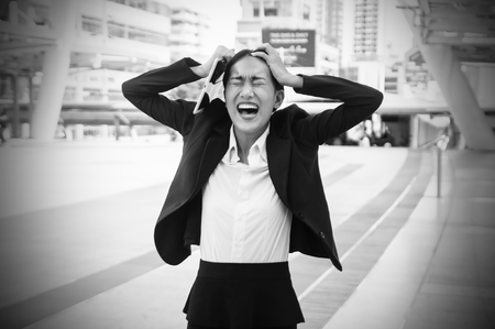 Portrait crazy Asian business woman screaming disappointed with her work.