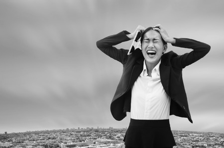 Portrait crazy Asian business woman screaming disappointed with her work.の写真素材