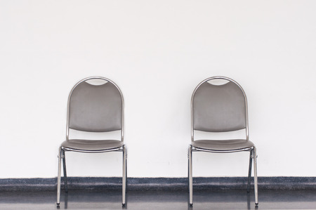 Queue waiting gray chair with wall in building.の写真素材