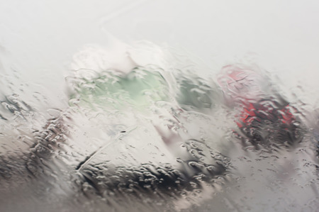 Raining with blur traffic background from car windows.