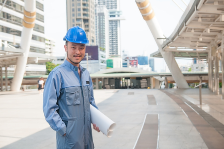 Asian engineer holding blueprint and floor plan in down town.の写真素材