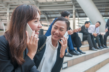 Asian business people relax talking on smartphone and many activity with their co-worker.の写真素材