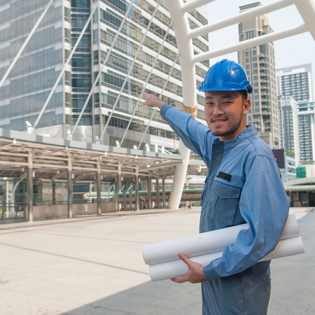 Asian engineer holding blueprint and floor plan in down town.の写真素材