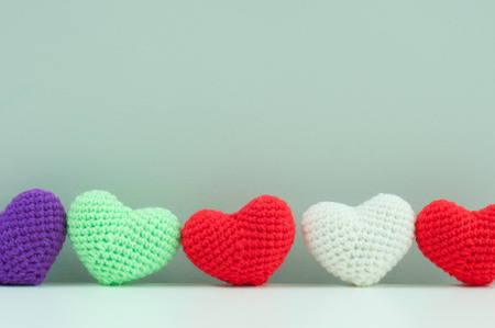 Red wool heart with white wings lay on white table with grey background, valentine love concept.の写真素材