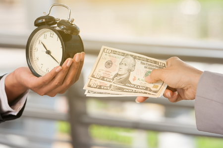 Unidentified business people use dollar bank note buy the time from other people, business concept time managing.の写真素材