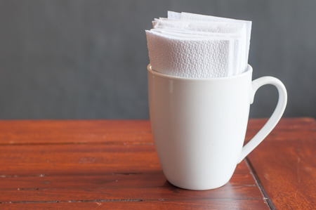 White tissues paper in white coffee mug in coffee restaurant.の写真素材