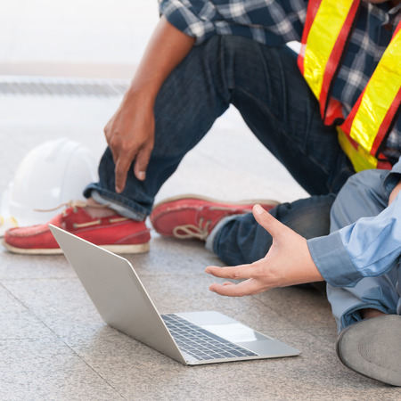 Unidentified civil engineer and other engineer sitting and work together good teamwork when checking...