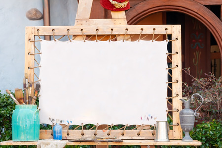 White canvas prepare for painting watercolor with wooden frame, many type of bushes in blue jar for paintingの写真素材