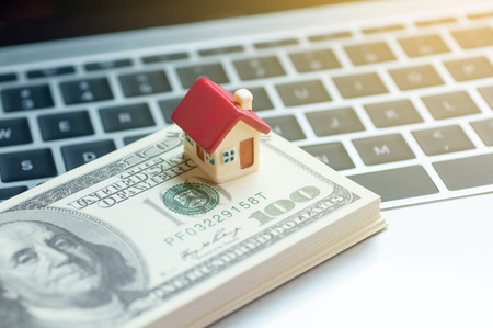 Real estate business concept, dollar banknote with miniature house mortgage, modern online marketing in real estate business.の写真素材