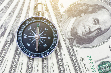 Dollar banknotes with compass, money and financial marketing direction conception.  Business strategy direction to make money.の写真素材