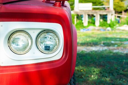 Close up classic red truck double headlight with white frame and  green yard,の写真素材