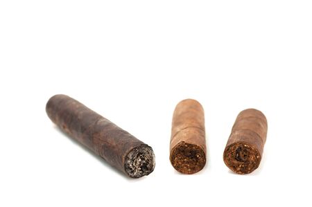 Cut and burned cigar on white background, world no tobacco day. Premium cigars from Havana, Cuba.の写真素材