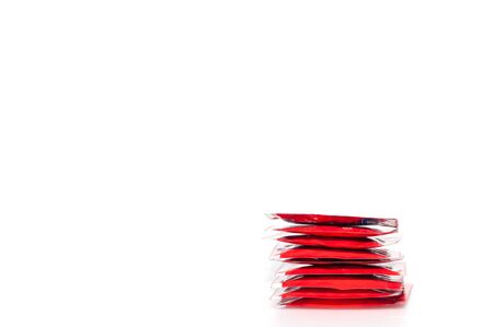 Stack of red condom package on white background, preventive safe sex.  Health conception.の写真素材