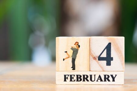 Selective focus people miniature woman, couple lover and wooden cube carlendar