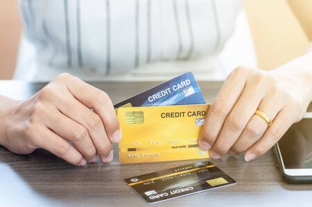 Unidentified woman in white dress holding credit card, personal financial credit, use credit cards...