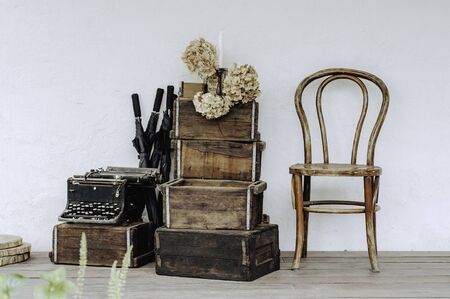 Interior vintage retro furniture stack of boxes chair and typewriter, still life photo conception.の写真素材