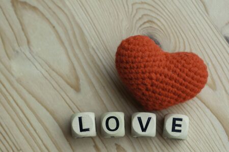 Red wool heart with cube wooden word love luv for valentine lover on wood table with copy space.