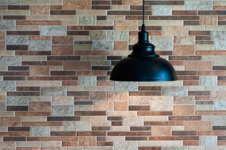 Vintage black lamp hang from ceiling with brick wall earth tone color.の写真素材