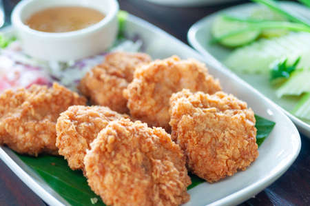 Shrimp cakes serve on green leaf in white plate on wooden table, favorite food Thailand.  Crispy shrimp cake.の写真素材