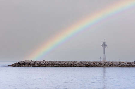 White local lighthouse on breakwaters line coastal protectionの写真素材