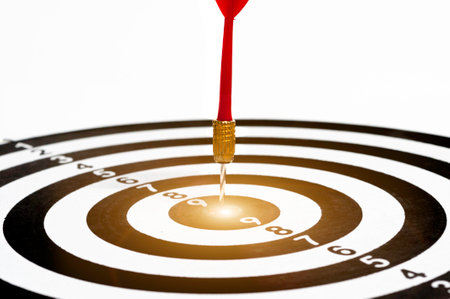 Red arrow hit on target dart board, business strategy planning to success goal.