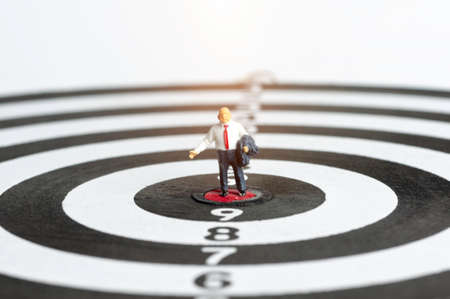 Successful business people standing with arrow hit on target, selective focus miniature business man congratulate on all the achievements in their career.の写真素材