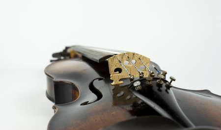 Perspective of old italian violin and focus on sound bridge on white background.