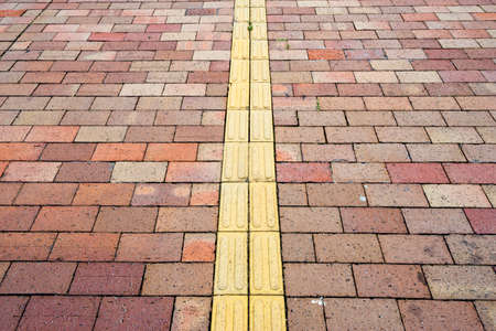 Yellow braille block on side walk.